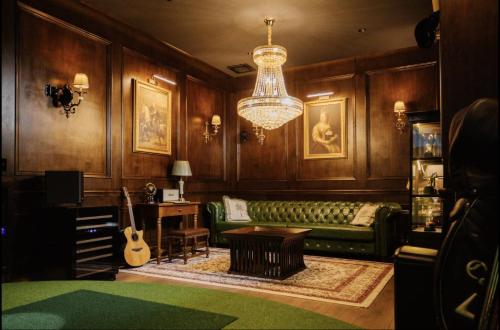 a living room with a green couch and a chandelier at Palm Villa - Award Winning Modern Luxury & Exclusive Villa in Chiang Mai