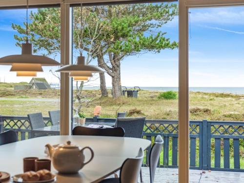 a dining room with a table and a view of the ocean at Holiday Home Djuna - 200m from the sea by Interhome in Læsø