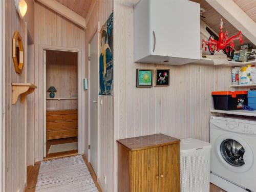 a small laundry room with a washer and dryer at Holiday Home Bille - 200m from the sea by Interhome in Læsø