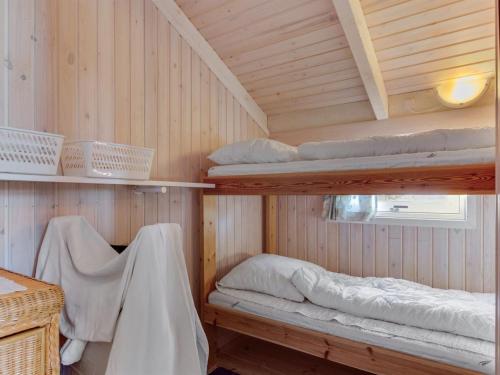a room with two bunk beds in a cabin at Holiday Home Bille - 200m from the sea by Interhome in Læsø
