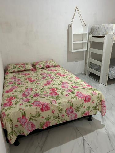a bedroom with a bed with a floral bedspread at Casa na Ilha de Itamaraca in Vila Velha