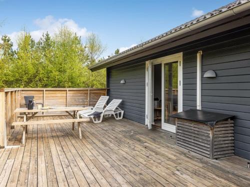 a deck with a picnic table and chairs on a house at Holiday Home Ellie - 300m from the sea by Interhome in Læsø