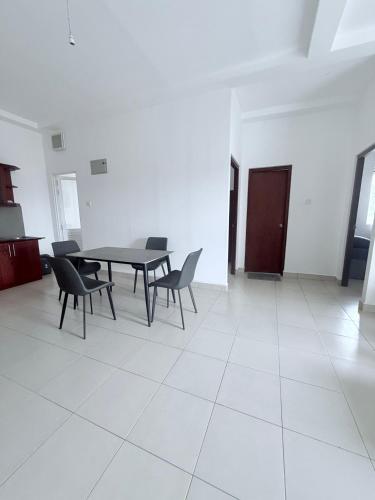 a dining room with a table and chairs in a room at The Clifford Suites By K&K in Homagama