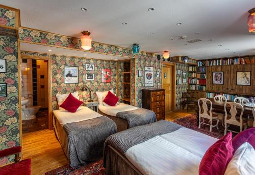a bedroom with two beds and a table and a desk at Hotell Gästis in Varberg