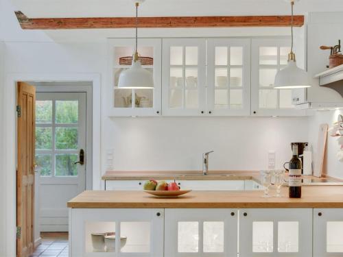 a kitchen with white cabinets and a bowl of fruit on the counter at Holiday Home Juhana - 150m from the sea by Interhome in Skagen