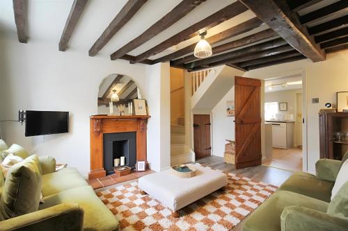 a living room with a couch and a fireplace at 28 Millgate Cosy Dog Friendly Cottage in Aylsham in Aylsham