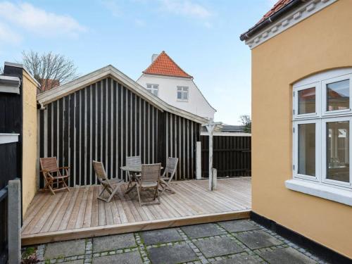 a wooden deck with a table and chairs on it at Apartment Ejler - 200m from the sea by Interhome in Skagen