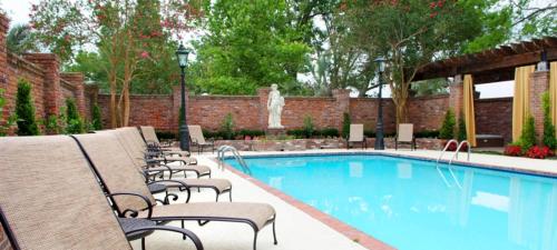 a swimming pool with chairs next to a brick wall at Nottoway Plantation and Resort in White Castle
