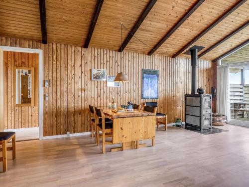 a dining room with a table and chairs and a stove at Holiday Home Thrineke - 200m from the sea by Interhome in Læsø