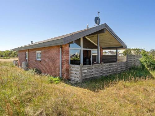 a small house on a hill in a field at Holiday Home Thrineke - 200m from the sea by Interhome in Læsø