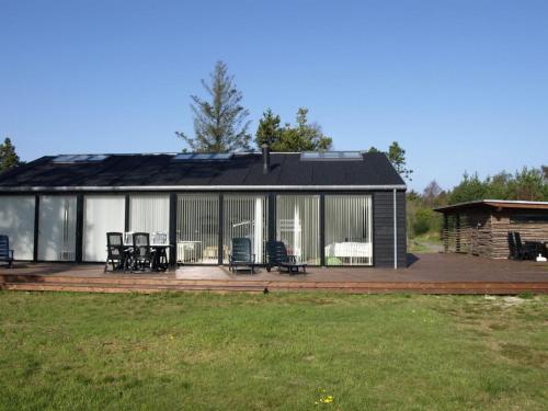 a house with a deck with chairs on it at Holiday Home Jonce - 400m from the sea by Interhome in Jerup