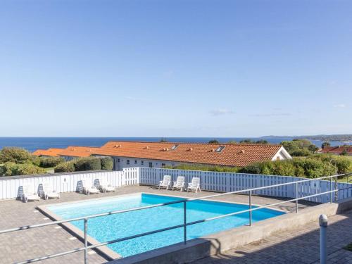 una piscina con sedie e un edificio di Apartment Thamina - 400m from the sea by Interhome ad Allinge
