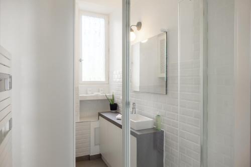 a white bathroom with a sink and a mirror at Bel Appartement à Orléans - Le Nid de L'ours - Unique refuge in Orléans