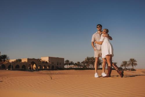 a man and a woman standing in the desert at Aldhafra Desert Resort, Vignette Collection by IHG in Madīnat Zāyid