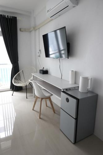 a room with a desk and a tv on the wall at Papaya Stay in Sathani Khlong Rian
