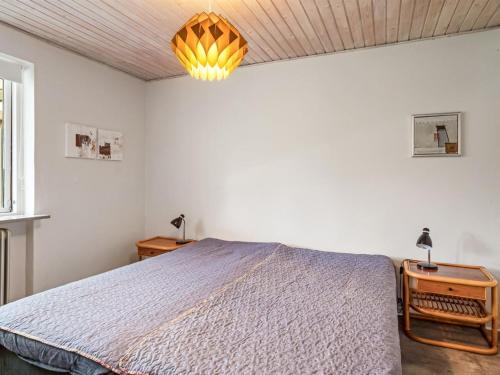a bedroom with a bed and a lamp on a table at Holiday Home Mats - 5-3km from the sea by Interhome in Løkken