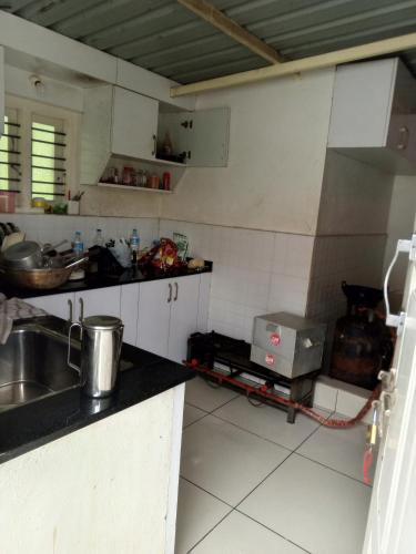 a kitchen with a sink and a counter top at HALASE HOMESTAY in Mudigere