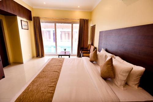 a bedroom with a large bed with a large window at ASJ Holiday Villa in Puducherry
