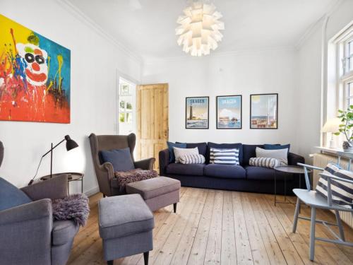 a living room with a blue couch and chairs at Holiday Home Ortrud - 200m from the sea by Interhome in Skagen