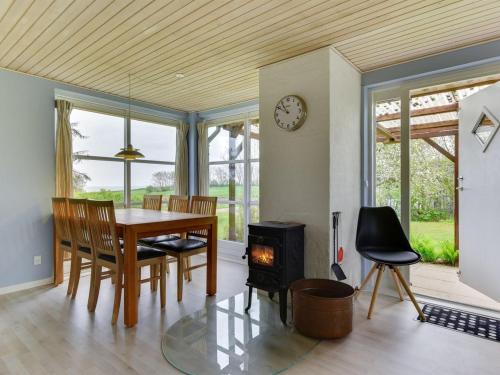 a dining room with a table and a wood stove at Holiday Home Venla - 150m from the sea by Interhome in Augustenborg