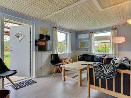 a living room with a couch and a table at Holiday Home Venla - 150m from the sea by Interhome in Augustenborg
