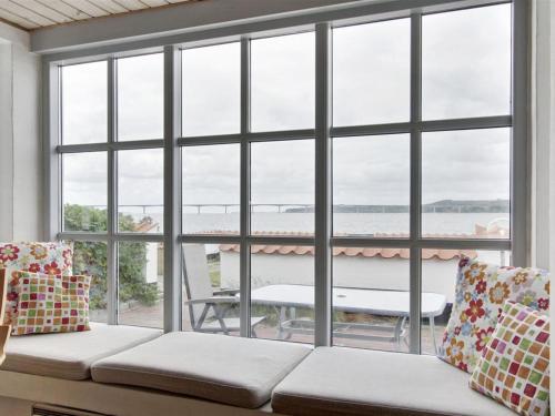 a living room with a couch and a large window at Holiday Home Pauliina - 10m to the fjord by Interhome in Roslev