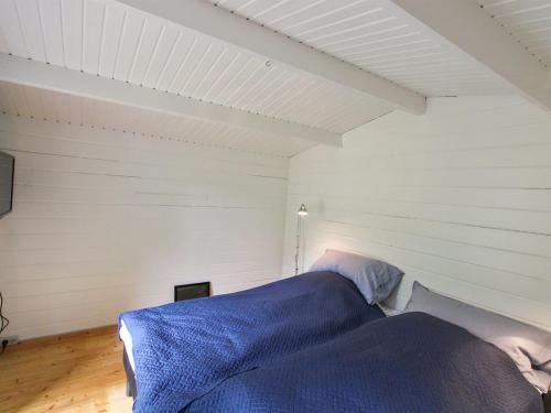 a bedroom with a bed with blue sheets on it at Holiday Home Othinkarl - 150m from the sea by Interhome in Neksø