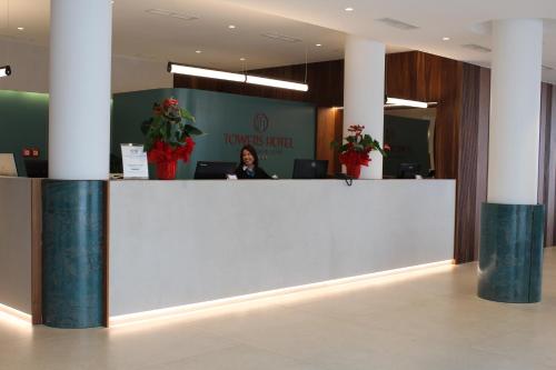 a woman sitting at a counter in an office at Towers Hotel Stabiae Sorrento Coast in Castellammare di Stabia