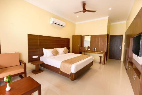 a bedroom with a large bed and a television at ASJ Holiday Villa in Puducherry