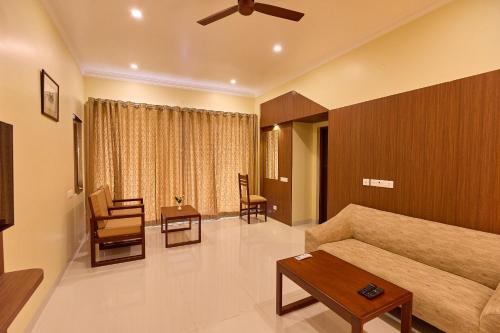 a living room with a couch and a table at ASJ Holiday Villa in Puducherry