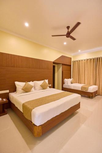 a bedroom with two beds and a ceiling fan at ASJ Holiday Villa in Puducherry