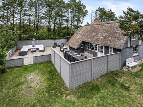 a backyard with a patio with a thatched roof at Holiday Home Annelisa - 200m to the fjord by Interhome in Ulfborg