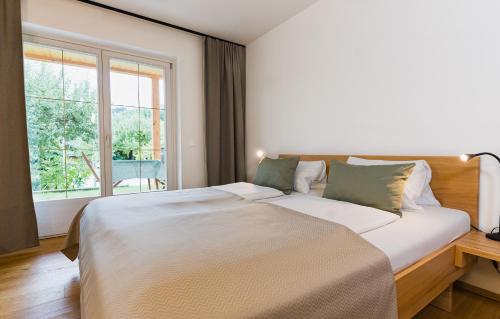a bedroom with a large bed and a window at Seespitz 37 - Ferienwohnungen Eisendle in Seeboden