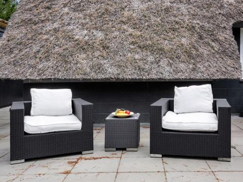 two chairs and a table in front of a building at Holiday Home Annelisa - 200m to the fjord by Interhome in Ulfborg