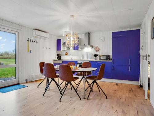 a kitchen with purple cabinets and a table and chairs at Holiday Home Arise - 700m from the sea by Interhome in Vejrø