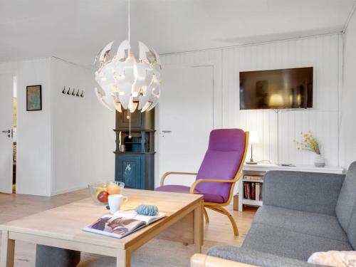 a living room with a table and a purple chair at Holiday Home Arise - 700m from the sea by Interhome in Vejrø