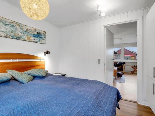 a bedroom with a blue bed with a blue comforter at Holiday Home Arise - 700m from the sea by Interhome in Vejrø