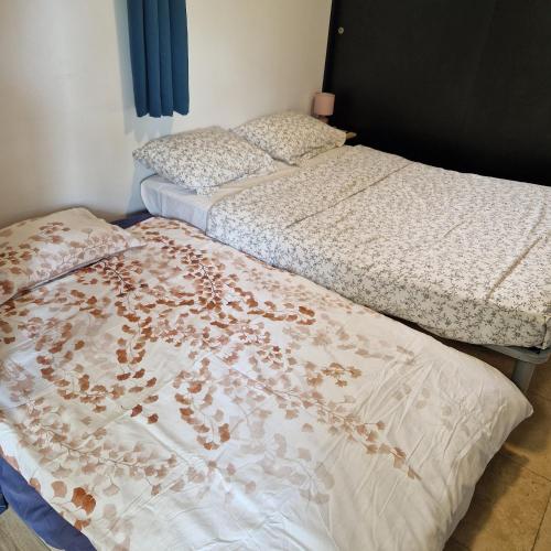 two beds sitting next to each other in a room at Grand logement 2 en 1 à Boucan Canot Plage in Saint-Gilles les Bains