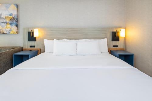 a large bed in a hotel room with blue tables at Comfort Inn in Laval