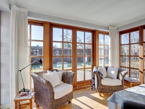 a living room with two chairs and windows at Holiday Home Iarund - 500m to the inlet by Interhome in Løgstør