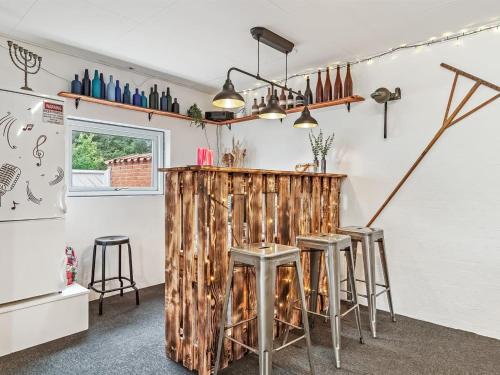 a kitchen with a wooden bar with stools at Holiday Home Kiersten - 5km from the sea by Interhome in Saltum