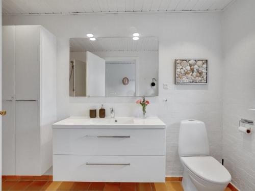 a white bathroom with a sink and a toilet at Holiday Home Kiersten - 5km from the sea by Interhome in Saltum