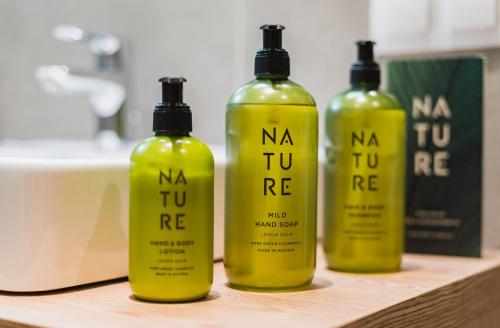 three yellow shampoo bottles sitting on a wooden shelf at Seespitz 37 - Ferienwohnungen Eisendle in Seeboden