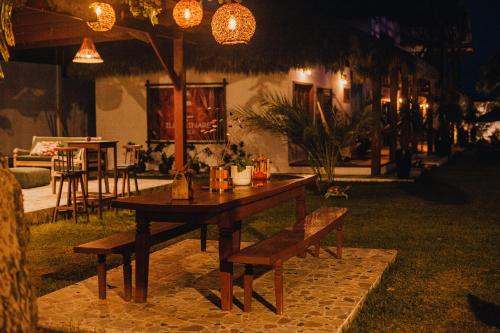 a wooden table and bench in a yard at night at Hotel de Charme Illuminare Stile in Fortim