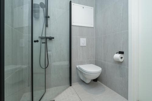 a bathroom with a toilet and a glass shower at MAYA Apartments - Parkveien in Oslo