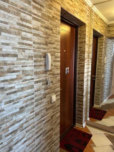 eine begehbare Dusche mit einem Telefon an einer Ziegelwand in der Unterkunft Стильна та затишна однокімнатна квартира на бульварі Шевченка с кондиціонером,поруч парковка з охороною in Tscherkassy