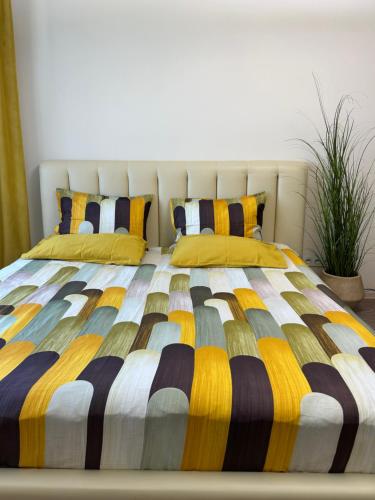 ein Bett mit einer bunten Bettdecke und zwei Kissen in der Unterkunft Стильна та затишна однокімнатна квартира на бульварі Шевченка с кондиціонером,поруч парковка з охороною in Tscherkassy