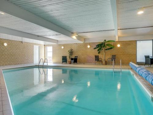 a large swimming pool with blue water in a building at Holiday Home Stilla - 35km from the sea by Interhome in Højer