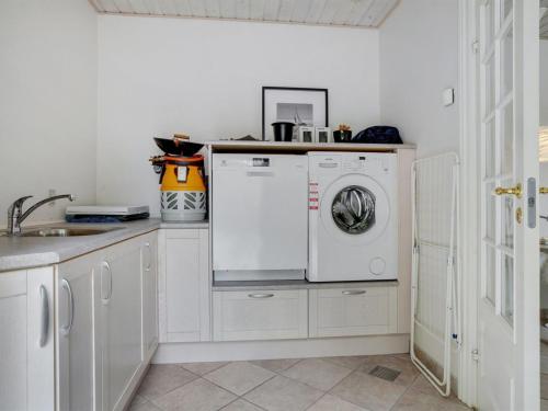 a kitchen with a washing machine and a sink at Holiday Home Neno - 2-2km from the sea by Interhome in Aså