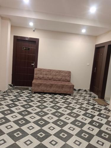a waiting room with a couch in front of a door at Shanti Meridian in Jāmb